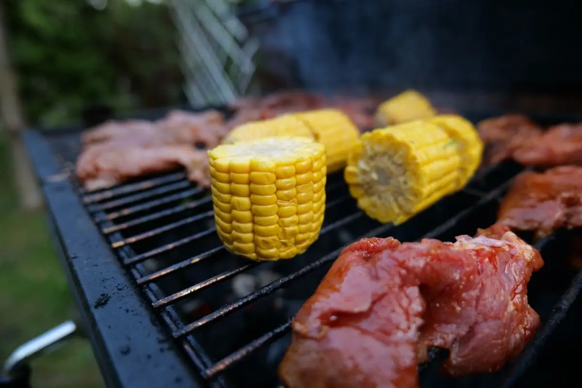 Kolby kukurydzy i mięso na grillu ogrodowym